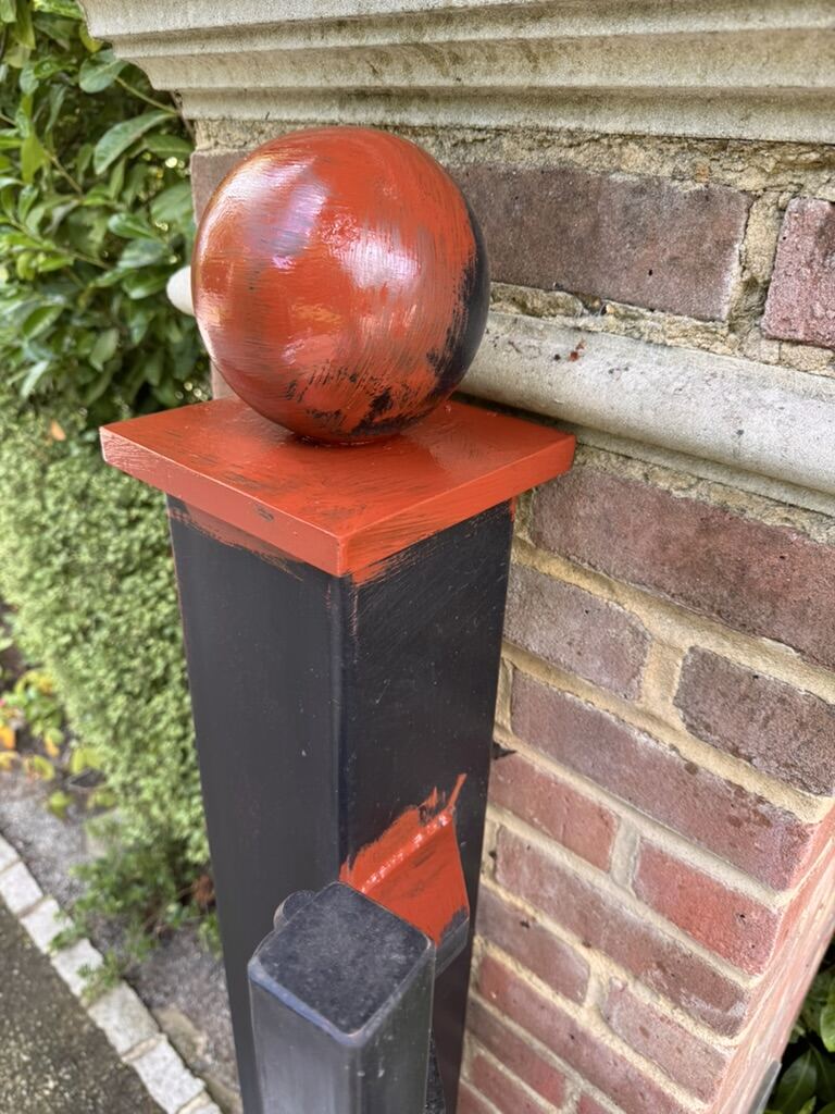Restored and repainted gate pillar with ball finial